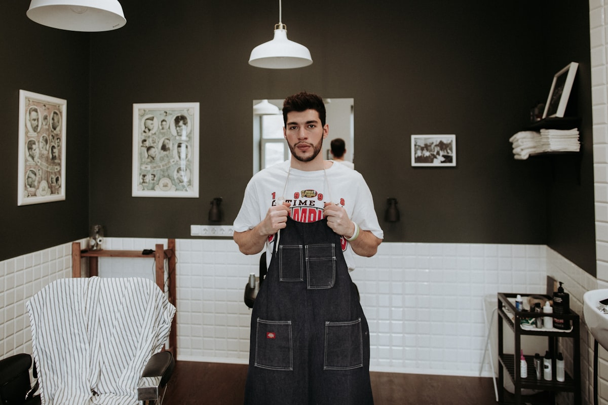 Barber putting on his apron in his own shop